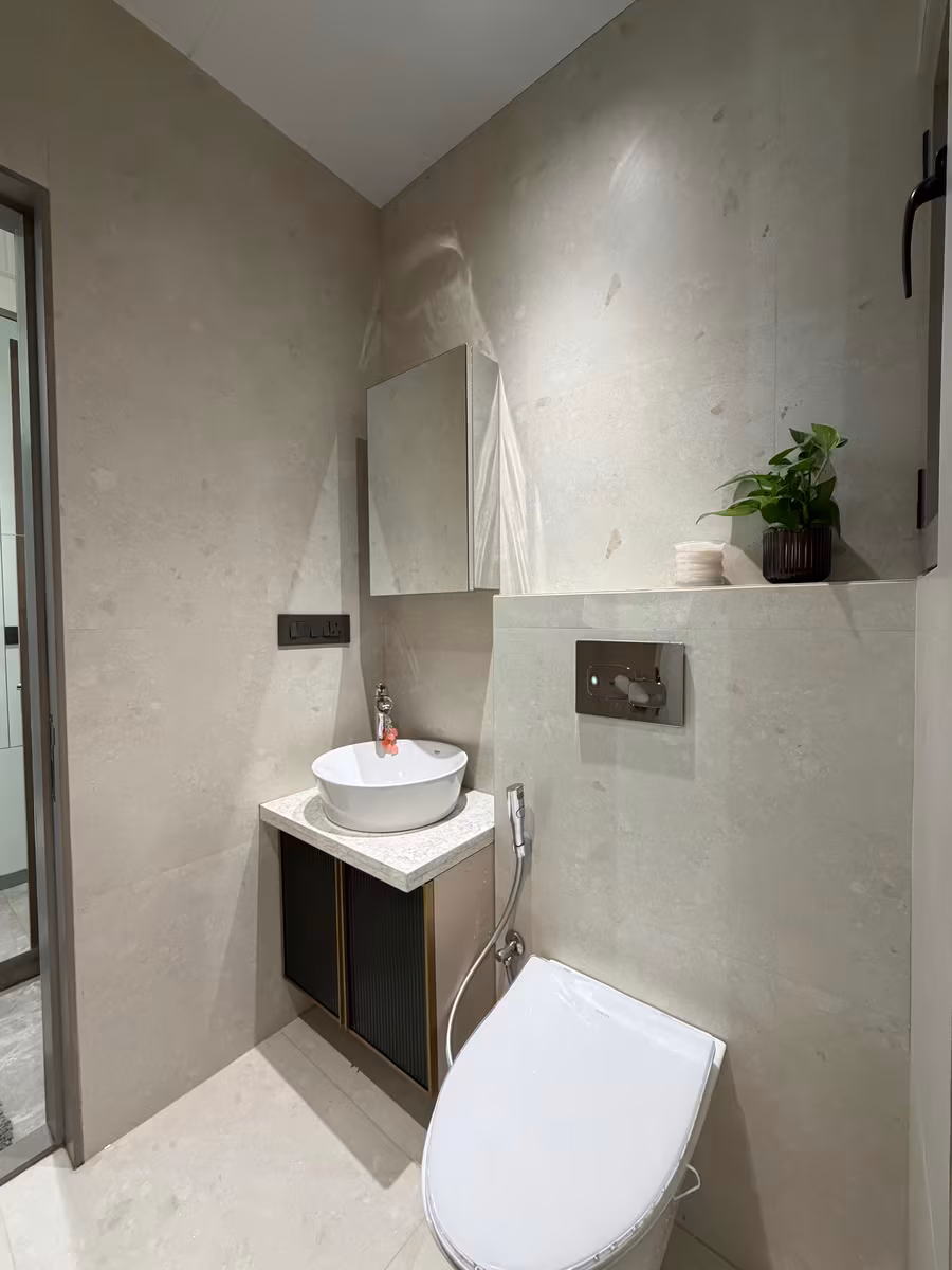 Compact bathroom finished in large-format stone-look tiles with a wall-hung vanity by ASK Design and Build