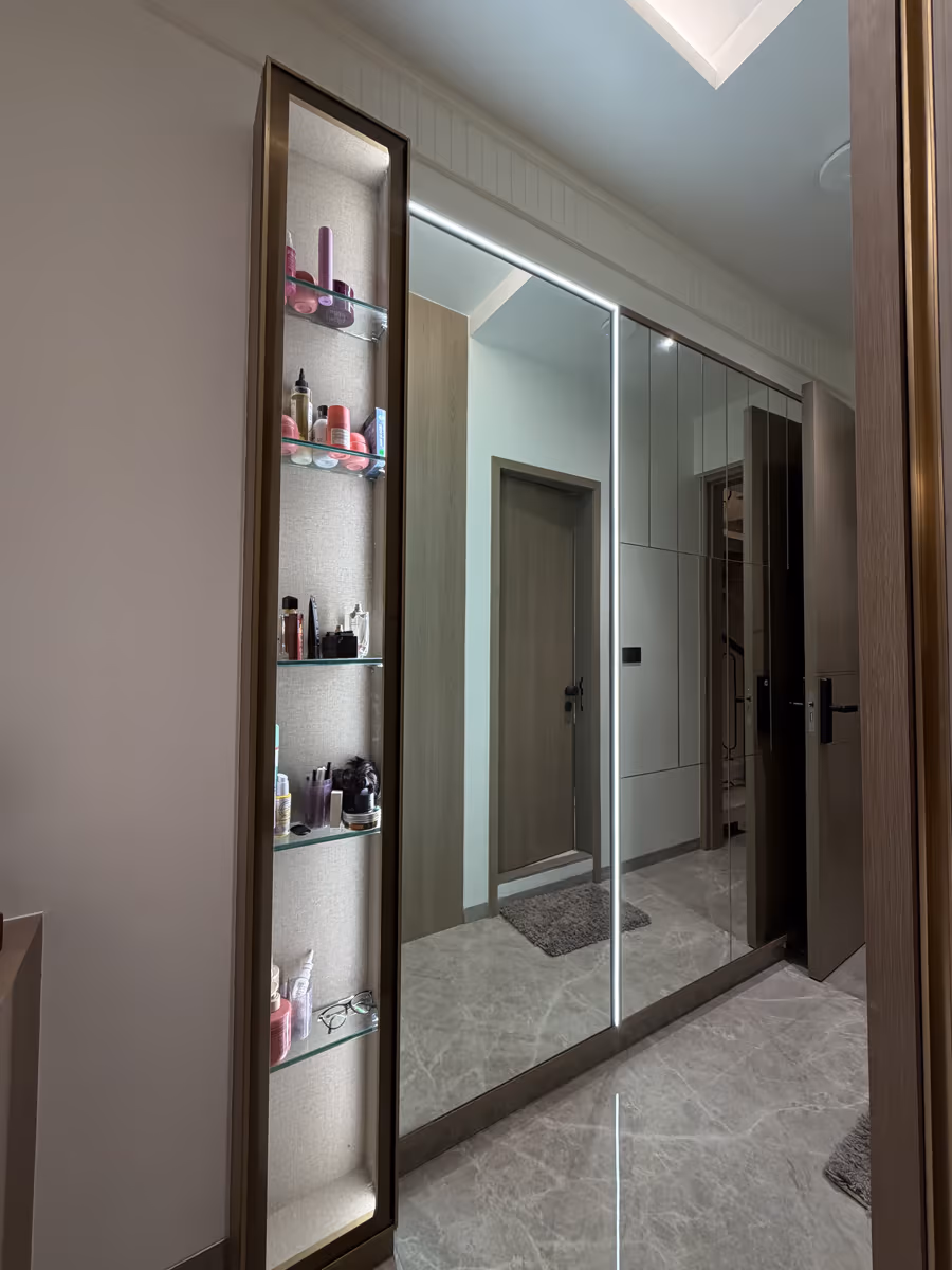 Backlit display shelving beside a mirrored wardrobe maximising storage by ASK Design and Build