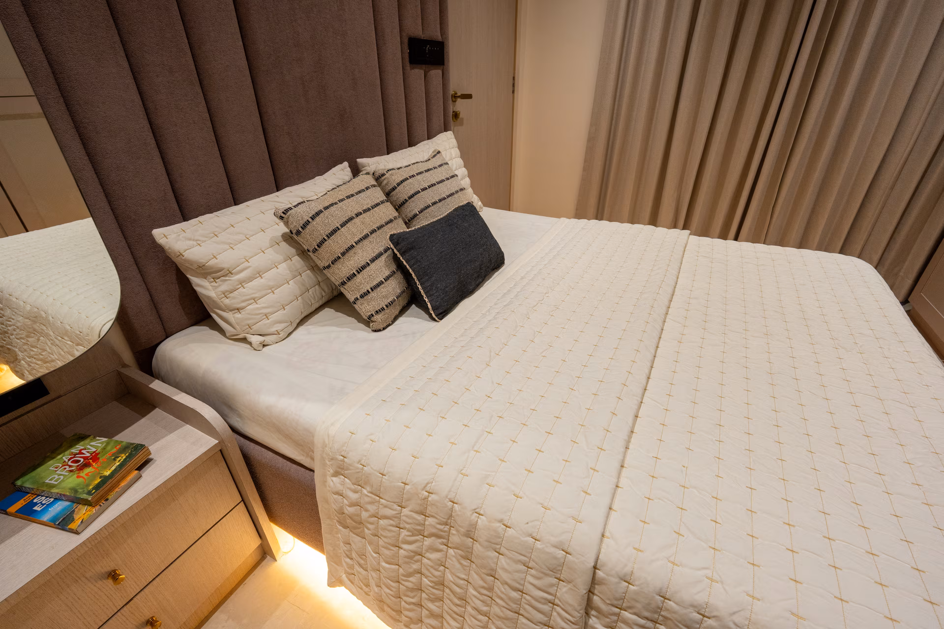 Bedroom styled in warm neutral tones with layered textures by ASK Design and Build