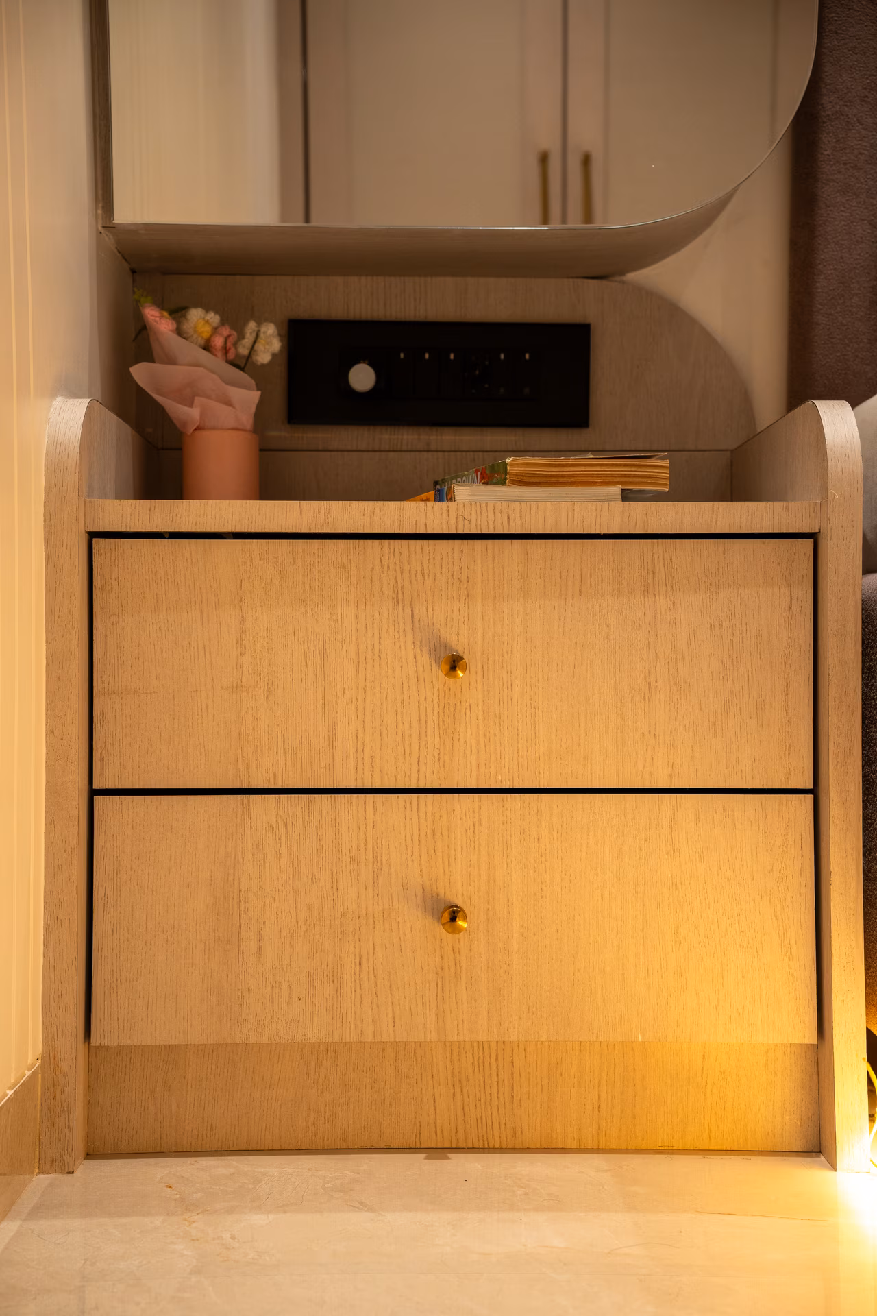 Bespoke bedside storage unit with warm accent lighting crafted by ASK Design and Build