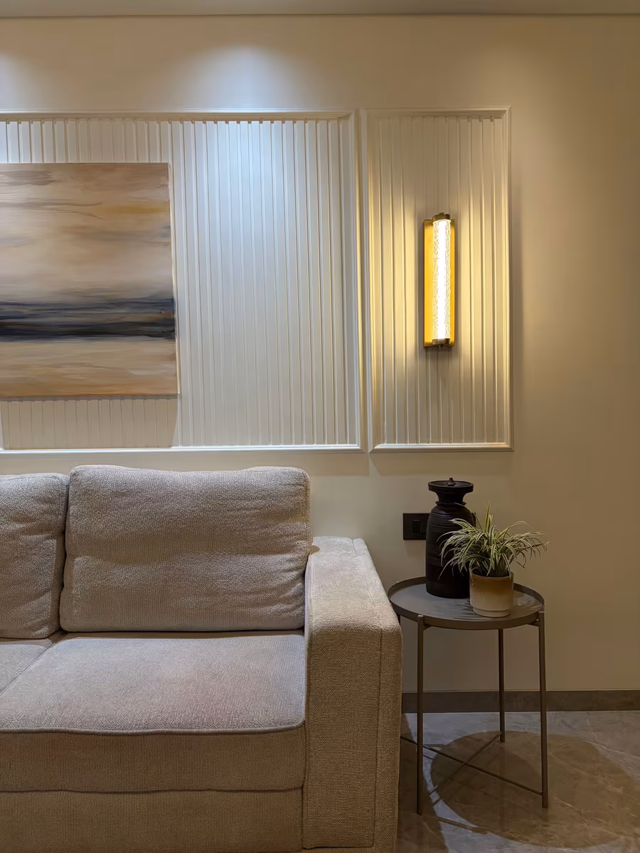 Neutral living room wall with fluted panelling, artwork and a vertical accent light by ASK Design and Build
