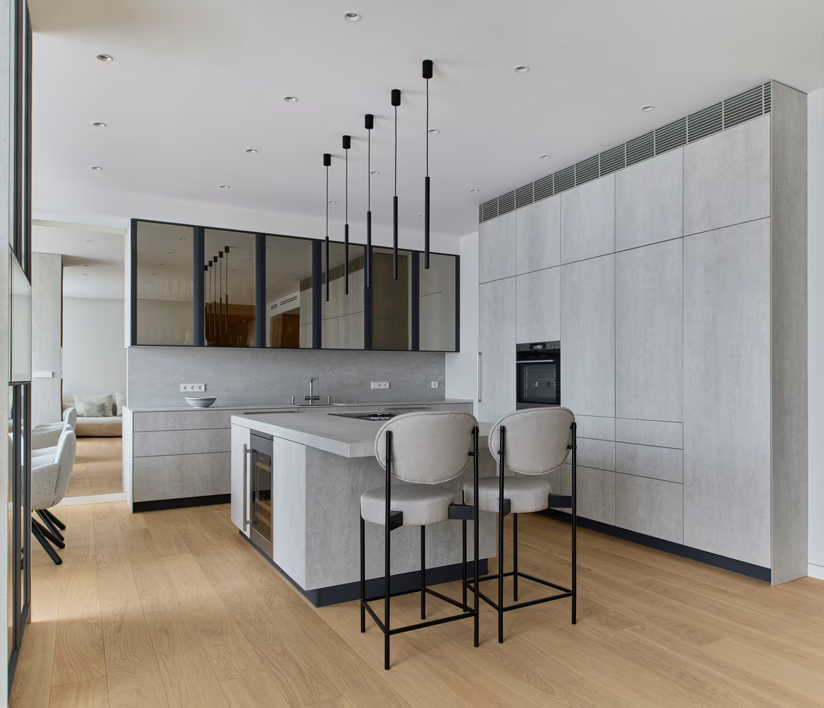Ultra-modern kitchen with concrete-effect cabinetry and linear black pendant lights