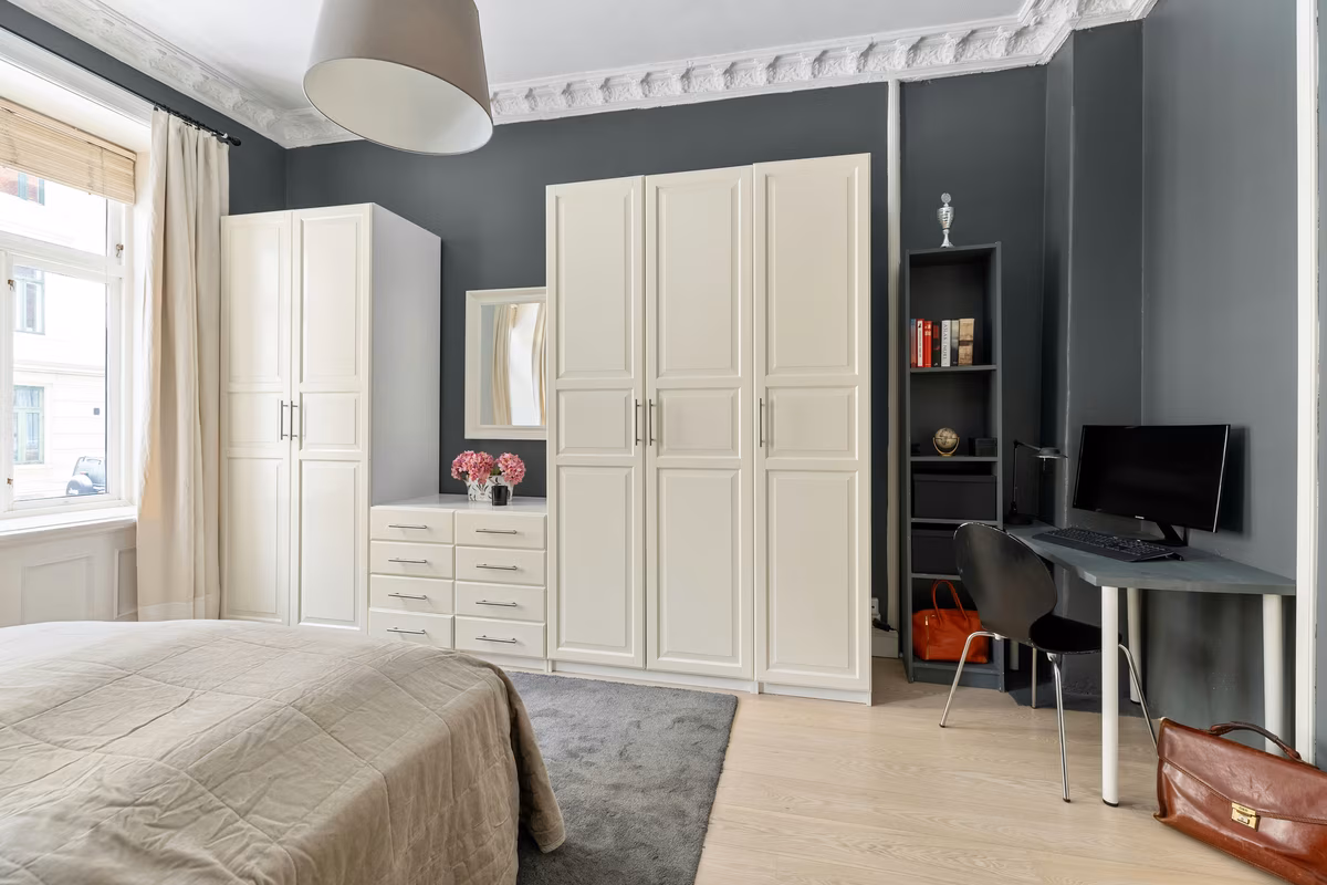 Traditional modern bedroom with cream panel wardrobes and integrated workspace