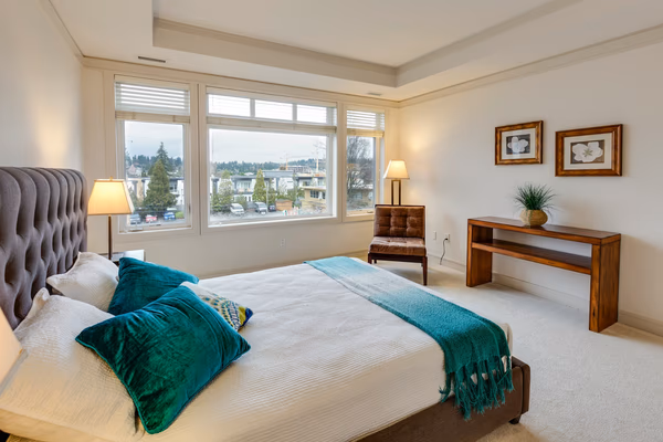 Contemporary master bedroom with emerald accents and city views