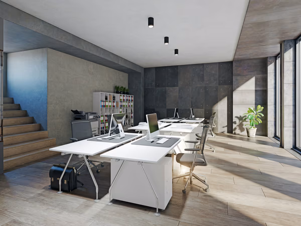 Minimalist open office with white desks, ergonomic chairs, and large windows