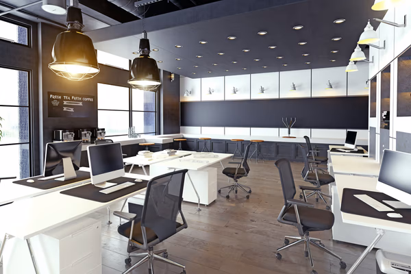 Contemporary office with white desks, ergonomic chairs, and a built-in coffee bar