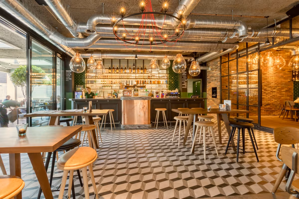 Industrial chic café with exposed ductwork, wooden tables, and eclectic decor