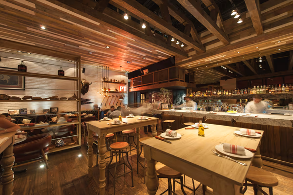 Rustic industrial restaurant with wooden beams, exposed brick walls, and eclectic decor