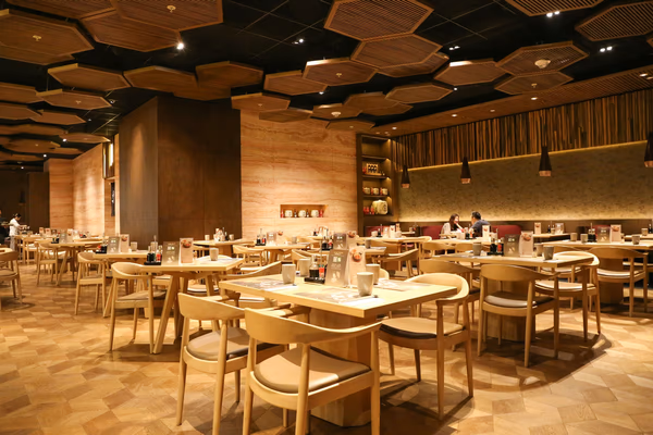 Contemporary dining restaurant with wooden tables, ambient lighting, and textured walls
