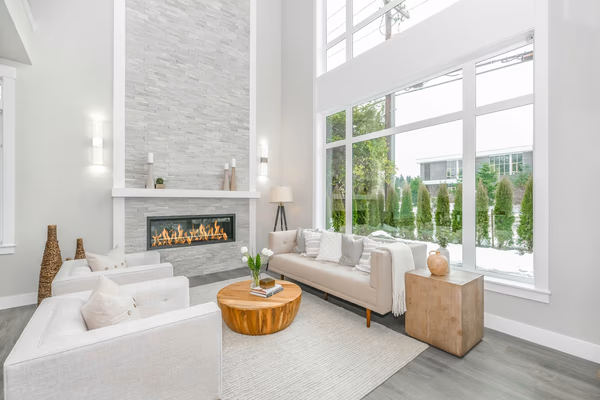 Modern living room with floor-to-ceiling stone fireplace and white furniture