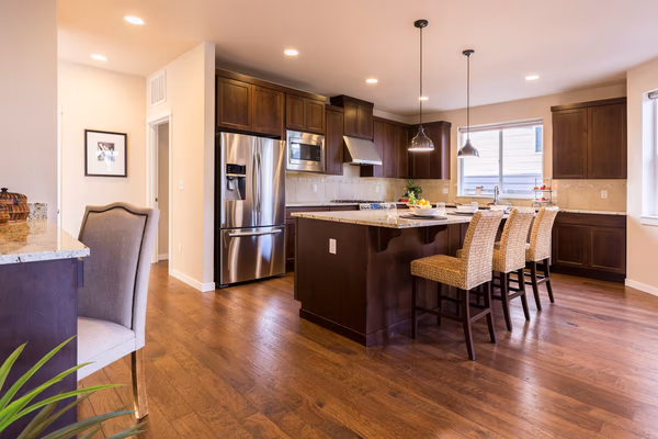 Contemporary kitchen with dark wood cabinets, granite countertops, and breakfast bar island