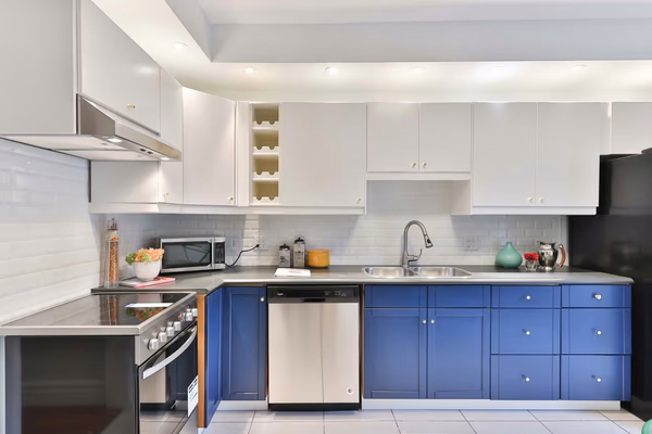 Modern galley kitchen with royal blue base cabinets and white upper cabinets