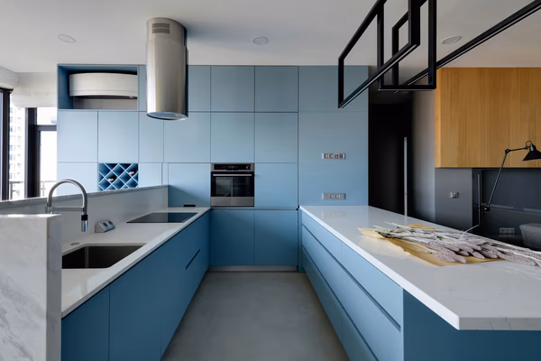 Contemporary U-shaped kitchen with powder blue cabinets and white quartz countertops