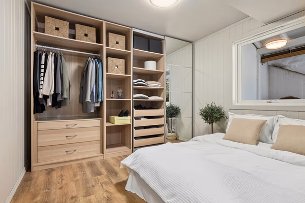 Light oak built-in wardrobe with integrated storage and woven baskets
