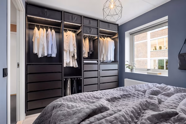 Modern black wardrobe with LED lighting and geometric pendant light