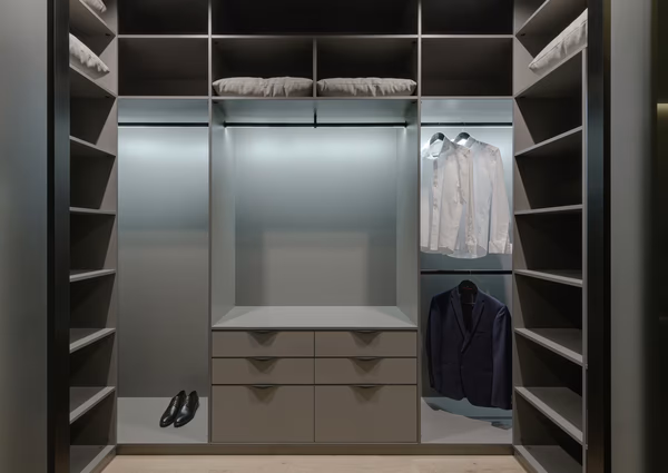 Modern U-shaped walk-in closet with LED lighting and grey finish